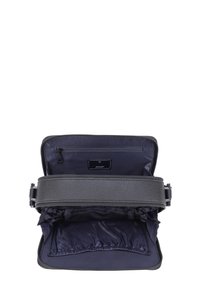 Sort tekstureret lædertaske med lynlåslukning, navy interiør med en lomme og en justerbar rem. Raffineret design med praktisk opbevaring.