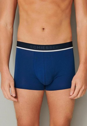 Marineblaue Boxer-Shorts mit einem schwarzen Bund, der weiße Akzentstreifen aufweist. Hergestellt aus einem glatten Stoff, bieten sie eine eng anliegende Passform.