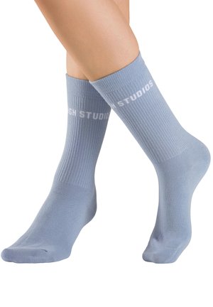 Blaue Baumwollsocken mit Rippenstruktur und weißem "SANDRO"-Logo nahe dem oberen Rand. Glatte Oberfläche und Standard-Sockenform.