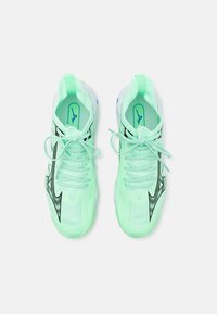 Scarpe sportive verde chiaro realizzate in materiali a rete e sintetici, con accenti neri, lacci piatti e un design a motivi.