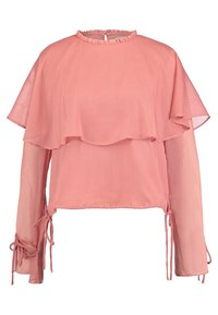 Blouse rose à manches longues en tissu transparent, avec col rond à volants, détail de cape superposée et liens aux poignets et à l'ourlet.