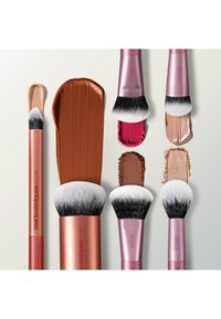 Fem sminkekoster med beige, brune, rosa og bronsefargede kosmetiske prøver på hvit bakgrunn, merket Real Techniques med modellnumre.