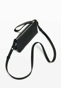 Sac bandoulière noir en matériau texturé, avec une fermeture éclair, une bandoulière ajustable et des motifs décoratifs gaufrés.