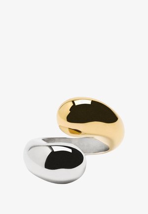 Złote i srebrne pierścionki o gładkim, zaokrąglonym, fasolowatym kształcie; lustro z wypolerowaną powierzchnią. Duży i minimalistyczny design.