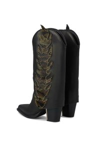 Botas de cuero negro hasta el tobillo con un diseño de hojas de camuflaje y acentos con tachuelas en la parte trasera. Punta afilada y tacón grueso.