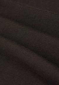 Dunkelbrauner Stoff mit glatter Textur und feinen Strickmustern. Das Bild zeigt gefaltete Lagen, die Tiefe und Weichheit vermitteln.