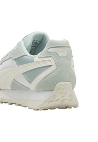 Zapatillas de deporte verde claro y blancas con material de ante y malla; cuentan con una suela texturizada y un logo bordado en el talón.