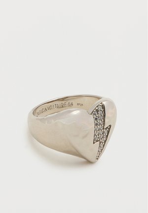 Silver ring featuring a smooth, rounded band with a lightning bolt accent embellished with small clear stones. Engraved interior details.