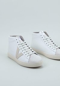 Zapatillas altas blancas de cuero y ante con un acento beige, que cuentan con una punta redonda, cierre con cordones y una suela de goma beige.