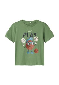 Camiseta de algodón verde con un personaje de baloncesto de dibujos animados con gafas de sol, sosteniendo balones de baloncesto y con el texto "juguemos NUEVA YORK."