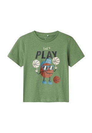 Camiseta de algodón verde con un personaje de baloncesto de dibujos animados con gafas de sol, sosteniendo balones de baloncesto y con el texto "juguemos NUEVA YORK."