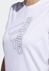 Hvid atletisk t-shirt med korte ærmer, der har en sort outline af "adidas"-logoet i et diagonaldesign hen over fronten.
