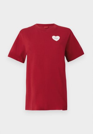 Red short-sleeve T-shirt with a small white heart patch on the left chest displaying the word "Hugo."