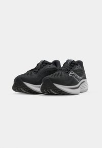 Black athletic shoes with mesh and synthetic upper, round toe, thick white midsole, and textured rubber outsole. Features lacing and subtle branding.