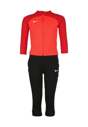 Veste zippée rouge à manches trois-quarts et pantalon court noir, tous deux en matériau extensible, avec des accents du logo Nike blanc.