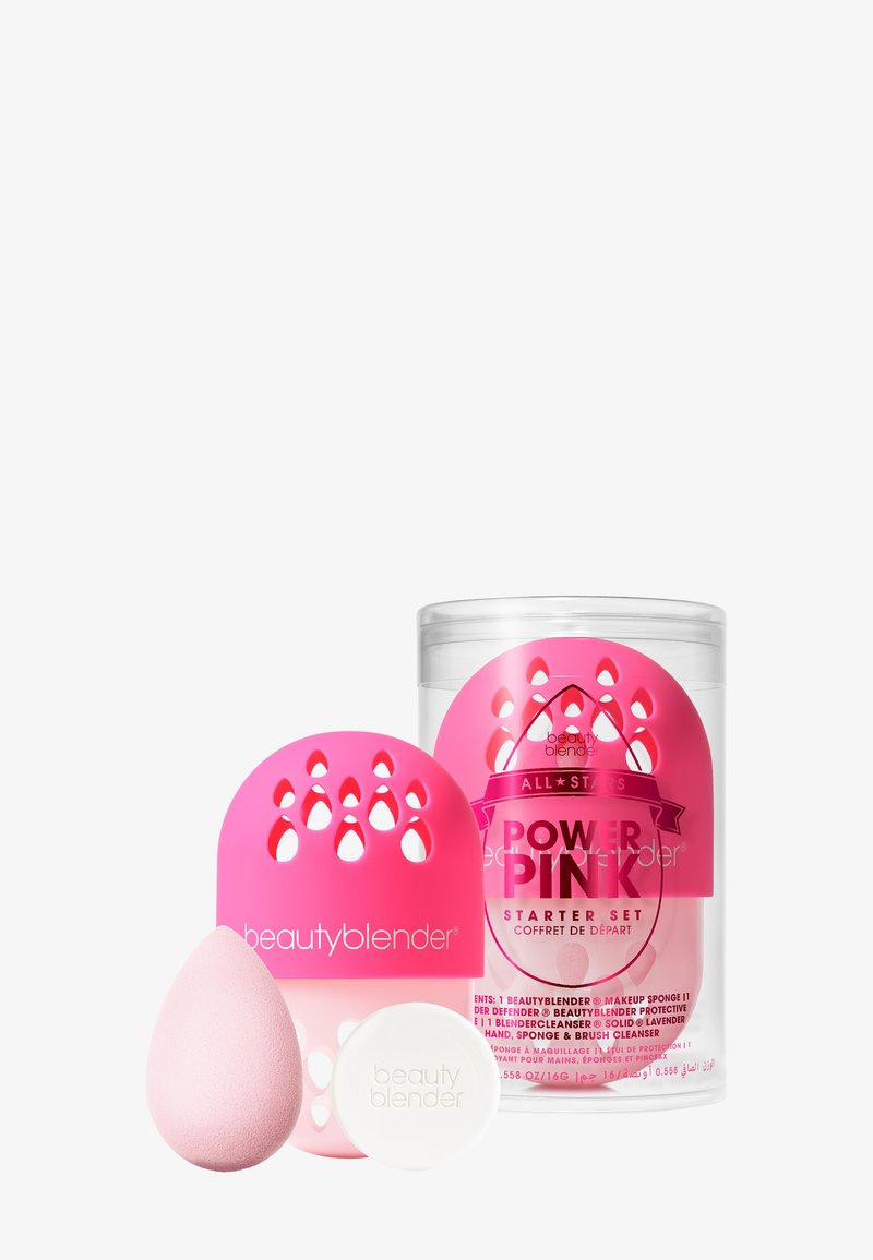 Zestaw startowy Beautyblender Power Pink: zawiera różową gąbeczkę do makijażu, białe mydło oraz różowe silikonowe etui do przechowywania z łezkowymi wycięciami.