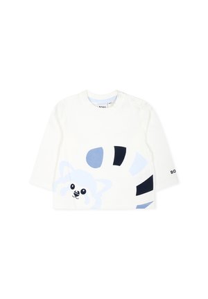 Witte long-sleeve shirt met blauwe dierenprint met een gestileerd wasbeer gezicht en zwarte strepen. Drukknopen sluiting op de schouder.