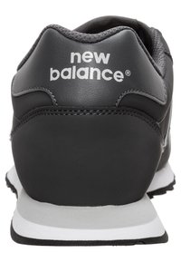 Musta nahkainen urheilukenkä, jossa on pehmustettu kaulus, harmaa tekstiilipäällyste ja valkoinen "new balance" -logo kantapäässä. Kumipohja.