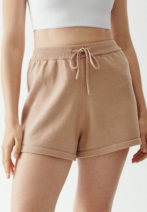 Beige gebreide shorts met een elastische tailleband en een trekkoord, omgeslagen zoom en een zachte textuur voor comfort.