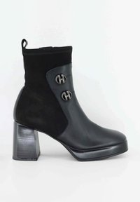 Stivaletto nero realizzato in pelle e suede, con tacco a blocco, dettagli con bottoni e superficie liscia con parte superiore texturizzata.