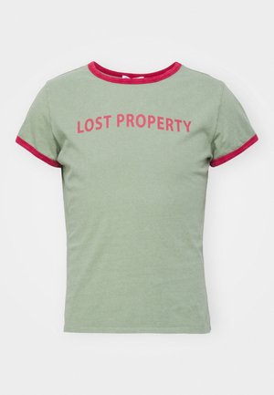 Jasnozielona koszulka z krótkim rękawem z czerwonym wykończeniem na kołnierzu i rękawach, z czerwonym napisem "LOST PROPERTY" na piersi.