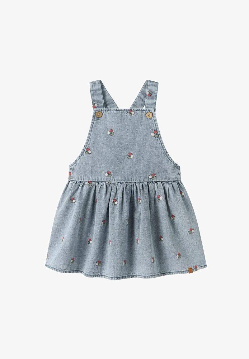 Robe salopette en denim bleu clair avec petits motifs floraux rouges et blancs, bretelles boutonnées et jupe froncée.