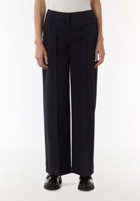 Weit geschnittene marineblaue Hose mit vertikalen Streifen, aus einem glatten Stoff gefertigt. Verfügt über eine flache Vorderseite, Seitentaschen und einen taillierten Schnitt.