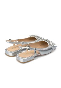 Bailarinas plateadas con un respaldo abierto, adornadas con una correa decorativa de joyas, que cuentan con un acabado metálico suave y un tacón bajo en bloque.