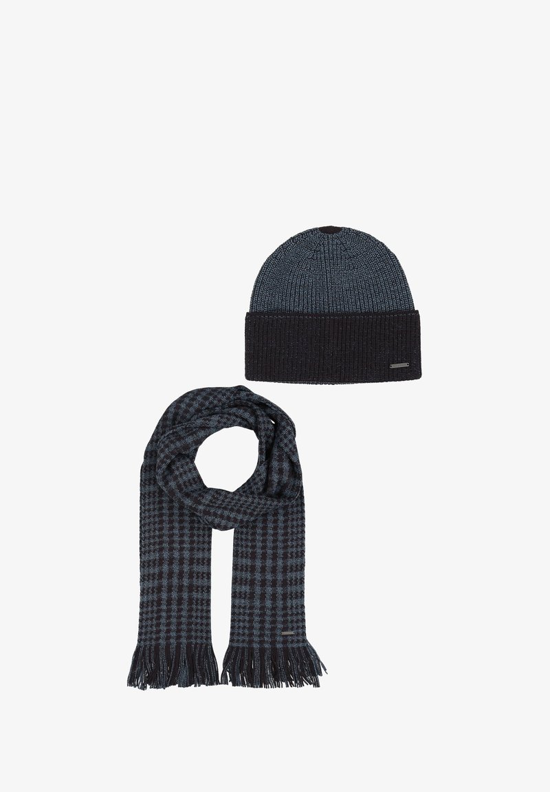 Temno modra pletena kapa z rebrastim robom in gladkim zgornjim delom; ujemajoč se šal s karirastim vzorcem in resicami na koncih.