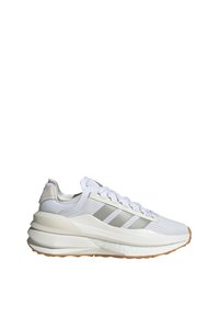 Zapato deportivo blanco con acentos grises, parte superior de malla, suela gruesa y acolchada, y tres franjas llamativas en el costado, que cuenta con una suela de goma.