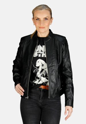 Black leather jacket with a fitted design, standing collar, zip closure, and shoulder accents, worn over a graphic t-shirt and dark jeans.