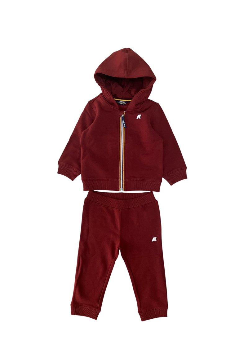 Completo in felpa rossa con cappuccio e pantaloni, caratterizzato da una chiusura con zip, cappuccio, polsini a coste e un piccolo logo sul petto e sulla gamba.