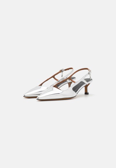Slingback hakken van glanzend zilver materiaal met een puntige neus, bruine banddetails en een kleine zwarte blokhak. Open zijkanten onthullen zwarte accenten.