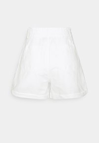 Shorts en lin blanc avec une coupe décontractée, dotés d'une ceinture élastiquée et de deux poches latérales ; texture lisse et ourlets retroussés.
