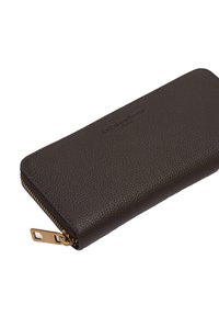 Brązowy skórzany portfel o teksturowanej powierzchni, z złotym zamkiem błyskawicznym i wytłoczonym logo na przodzie. Kompaktowy, prostokątny kształt.