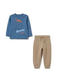 Felpa blu con grafica di dinosauro e testo "Sempre Giocoso", abbinata a pantaloni jogger beige con vita elasticizzata.