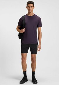 Men's purple athletic t-shirt paired with black shorts. Material appears lightweight, smooth texture, with a round neckline and short sleeves.