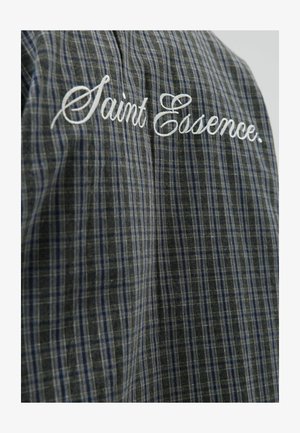 Plaid shirt in dark gray and blue, featuring white embroidered text "Saint Essence." Made of lightweight fabric with a soft texture.