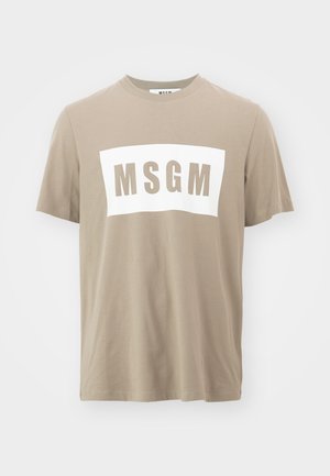 Beige puuvillainen t-paita lyhyillä hihoilla, jossa on suuri valkoinen suorakaiteen muotoinen paneeli ja "MSGM" painettuna paksuilla harmailla kirjaimilla.