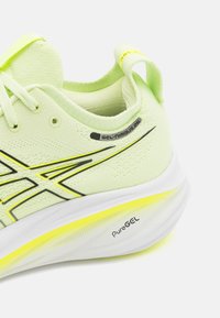 Scarpa da corsa sintetica verde chiaro con tomaia testurizzata, dettagli neri e suola bianca con un particolare giallo e il marchio "PureGEL".