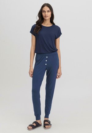 Navy-blaues Lounge-Set mit einem kurzärmeligen Oberteil und tapered Hosen mit elastischem Bund und Knopfakzenten. Weicher, leichter Stoff.