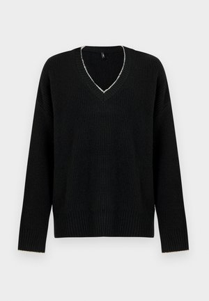 Svart oversize tröja med djup V-ringning, ribbad struktur och långa ärmar. Märkbar ljust färgad söm runt halsringningen.