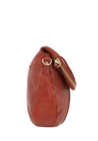 Brūna ādas somiņa ar apaļu formu, izceltu zelta rāvējslēdzēju un dekoratīvu aparatūru. Texturēts virsmas materiāls ar redzamām šuvēm.