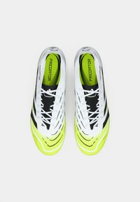 Pair of white and neon yellow Adidas Predator soccer cleats viewed from above, with black laces and black stripes.
