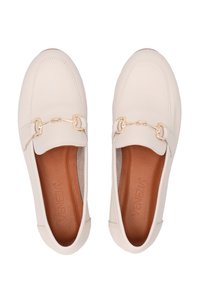 Beige Leder Slipper mit runder Zehenpartie, die ein goldenes Kettenakzent über dem Obermaterial und eine strukturierte braune Innensohle aufweisen.