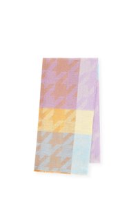 Écharpe pliée avec un grand motif pied-de-poule dans des teintes pastel de violet, orange, jaune et bleu sur un fond blanc.