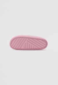 Rosa gummi såle med teksturerte gripe mønstre og ribbede kanter, med avrundet front og flat bakside for stabilitet.