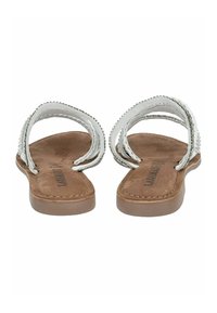 Sandali piatti bianchi con due cinturini intrecciati con accenti metallici, un sottopiede in suede marrone e una suola in gomma marrone resistente.