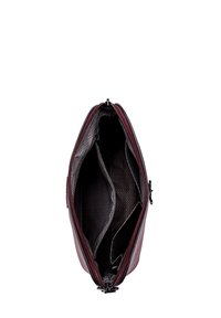 Bordeauxfarbene Leder-Tasche mit einem Reißverschluss, ausgestattet mit einem schwarzen Zickzack-Muster-Futter und zwei Innenfächern zur Organisation.