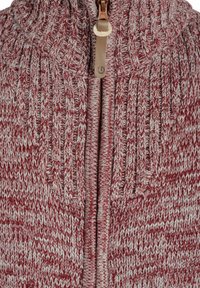Suéter de punto con cuello alto, que presenta un patrón en zigzag rojo y gris, un cierre frontal con tirador de cuero y textura acanalada.